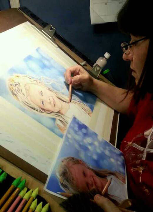 Gina 
                        working on a colored pencil painting